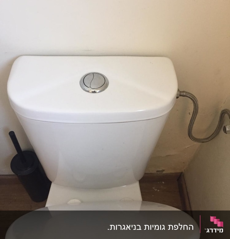 אסלה עם מכסה פתוח וצינור מים מחובר
